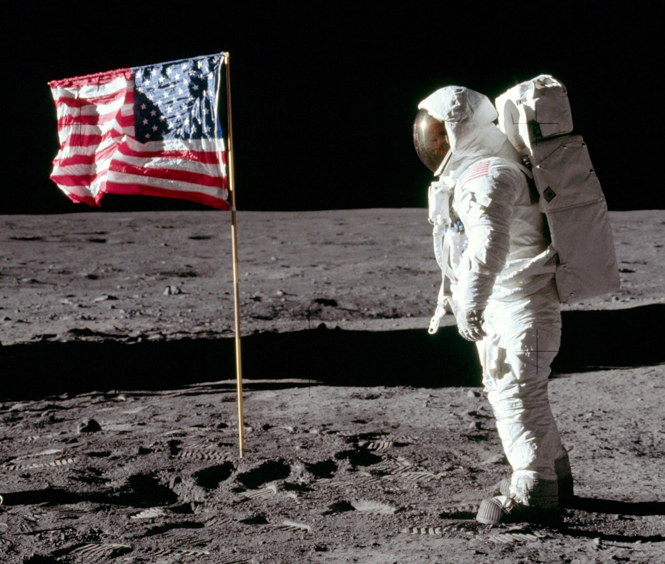 Lunar Photograph from Apollo 11 mission, 1969, documenting an astronaut saluting the American flag on the Moon's surface.