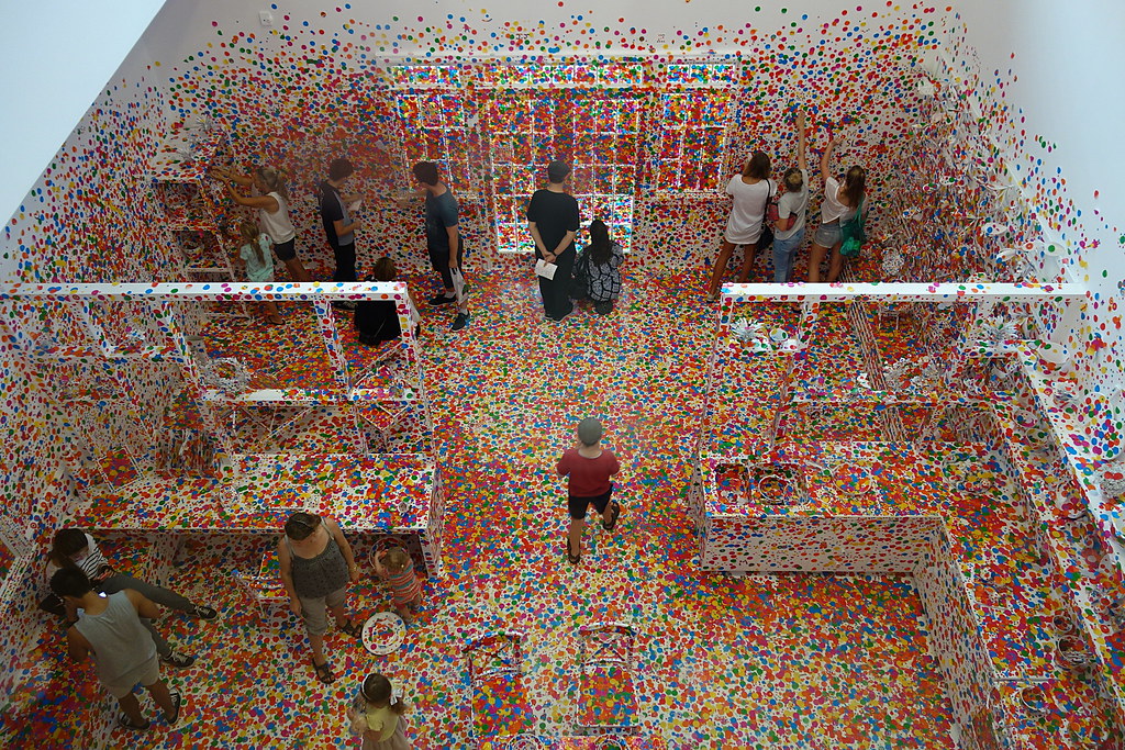 Yayoi Kusama's Obliteration Room — visitors cover every surface with coloured dot stickers, dissolving the space into infinity.
